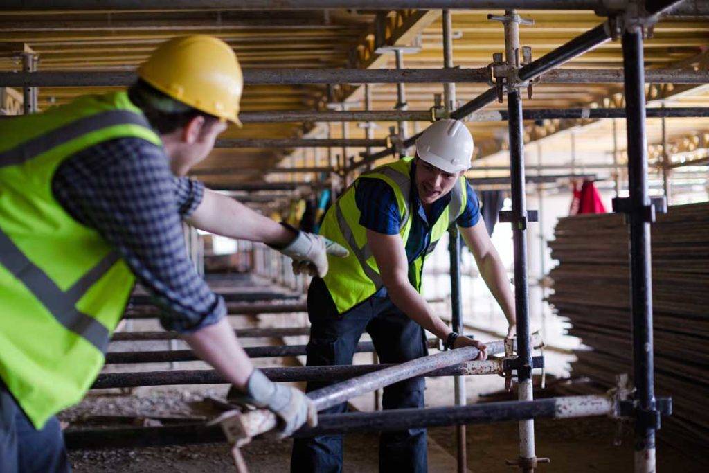 Constructor Workers Assembling Rebar Structure At Construction S